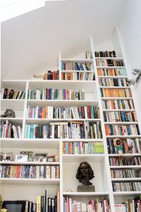 Very tall Contemporary modern Home library with asymeterical shelving