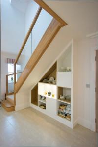 Modern fitted cupboards under stairs with shelving