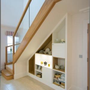 Modern fitted cupboards under stairs with shelving