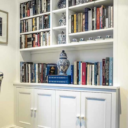 Ornate fitted cabinets and shelving traditional period design with detailed mouldings and cornicing