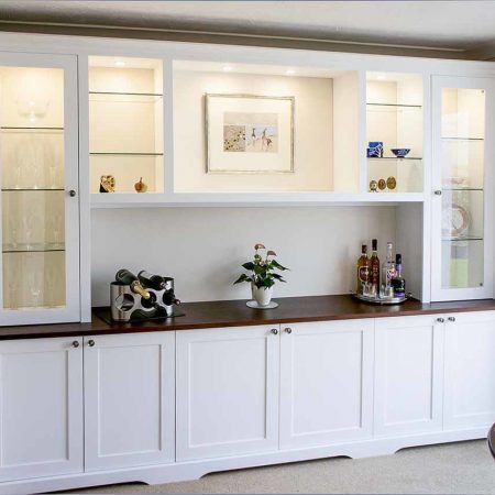 Large fitted cupboards with reeded glazed display cabinet doors combining storage and display