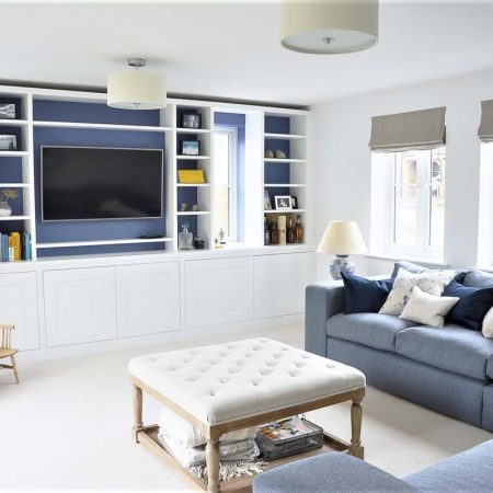 Wall to wall fitted living room cabinets with dark contrast backing and open display shelving
