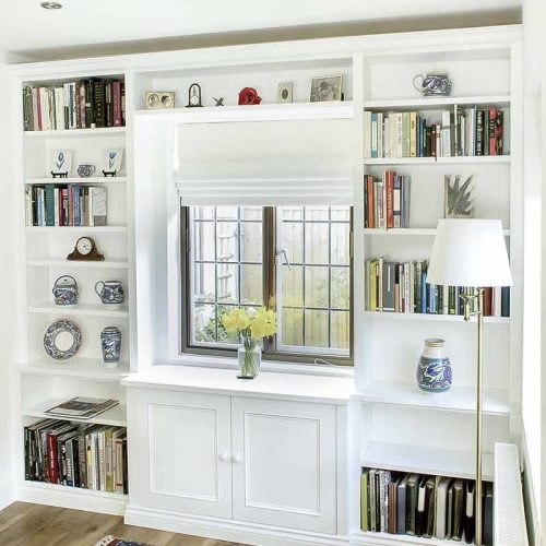 Bespoke fitted bookcases surrounding a break front cabinet