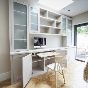 Contemporary grey painted fitted home office - Pull out desk for occasional use - with glazed upper cabinets, integrated desk and open shelving