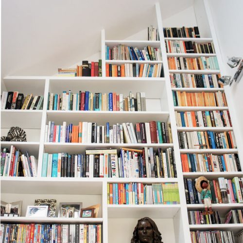 Very tall Contemporary modern Home library with asymeterical shelving