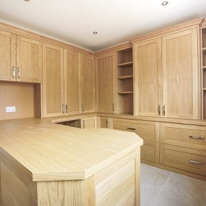 Bespoke fitted home office in natural oak with corner desk, floor-to-ceiling shelving and full perimeter storage