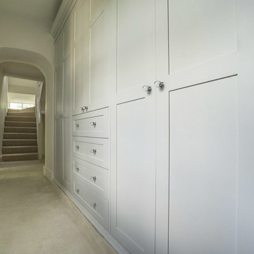 Period Victorian wardrobe fitted to a narrow hallway. Detailed with panelled shaker doors, finished with detailed plinth and cornice detail and fluted pilasters